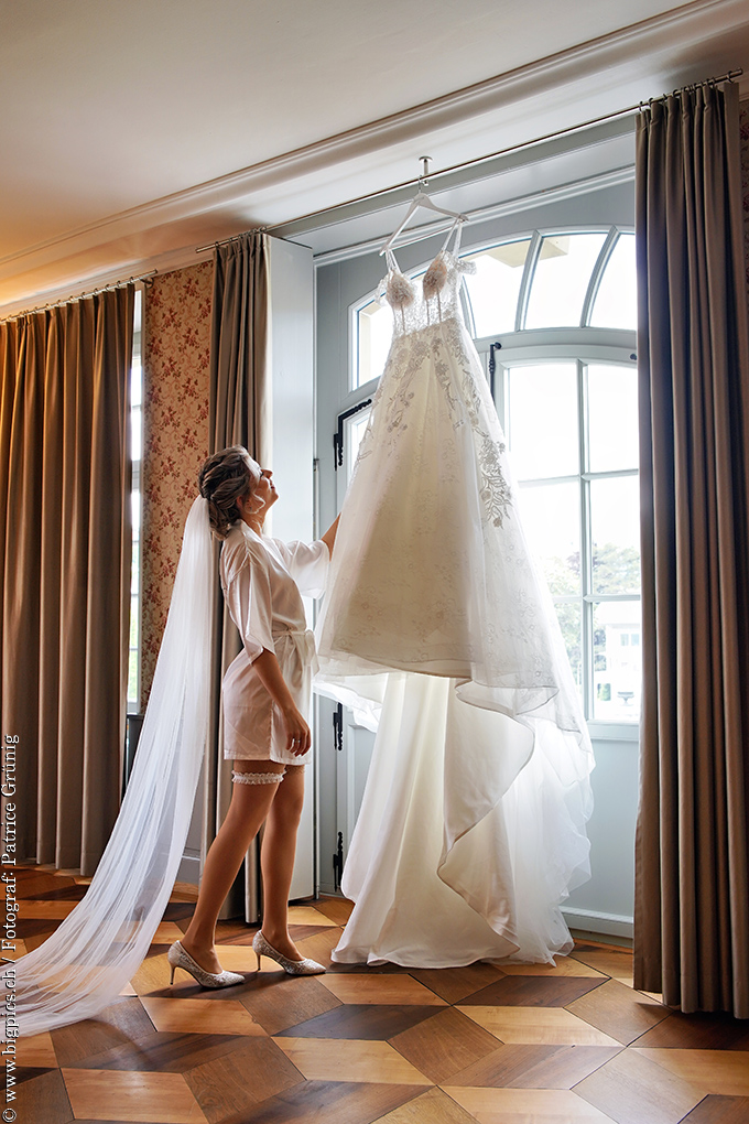Getting Ready Fotoshooting
Die Hochzeitsbraut schaut Ihr Kleid, das am Fenster hängt an.
Urheber Hochzeitsfotograf Patrice Grünig