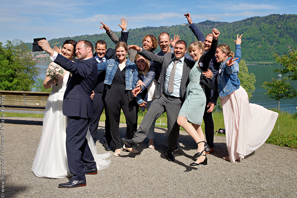 Gruppenfoto, das Liebespaar macht ein Selfie mit den Gästen im Hintergrund
Ein tolles Gruppenfoto vom Hochzeitsfotograf